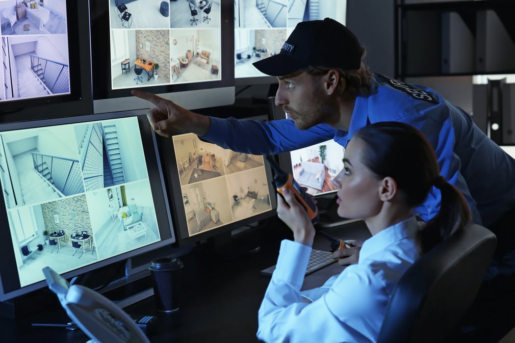 Security Guards Monitoring Modern CCTV Cameras in Surveillance Room